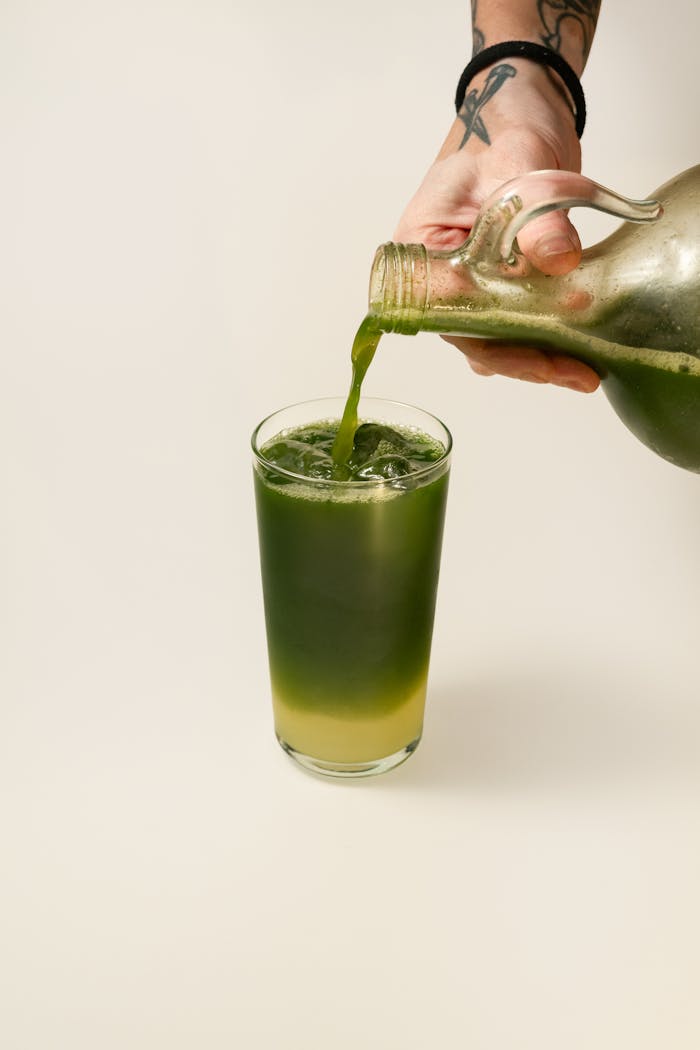 Refreshing green juice poured into a glass, perfect for a healthy lifestyle.